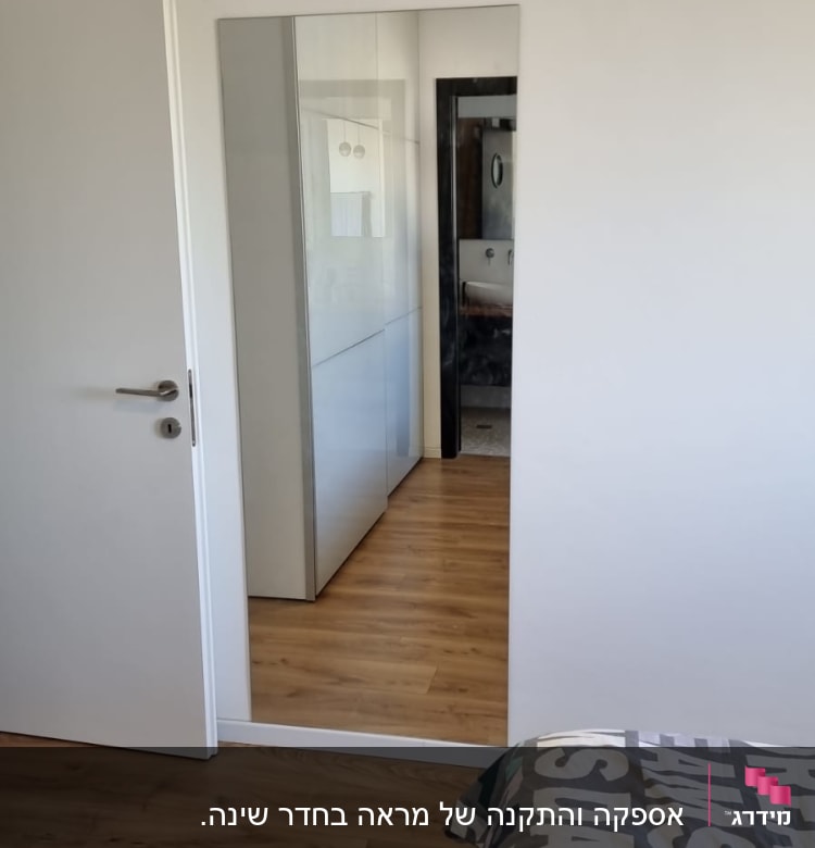 מראה גדולה על קיר לבן בחדר שינה